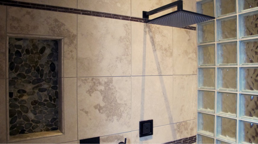 Master shower with Durango crossut travertine and glass block walls. Accent border tile copper leaves with shampoo niched. modern fixtures in brushed antique bronze.
