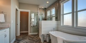 Master bathroom free-standing tub herringbone tile floor walk-in shower wainscot