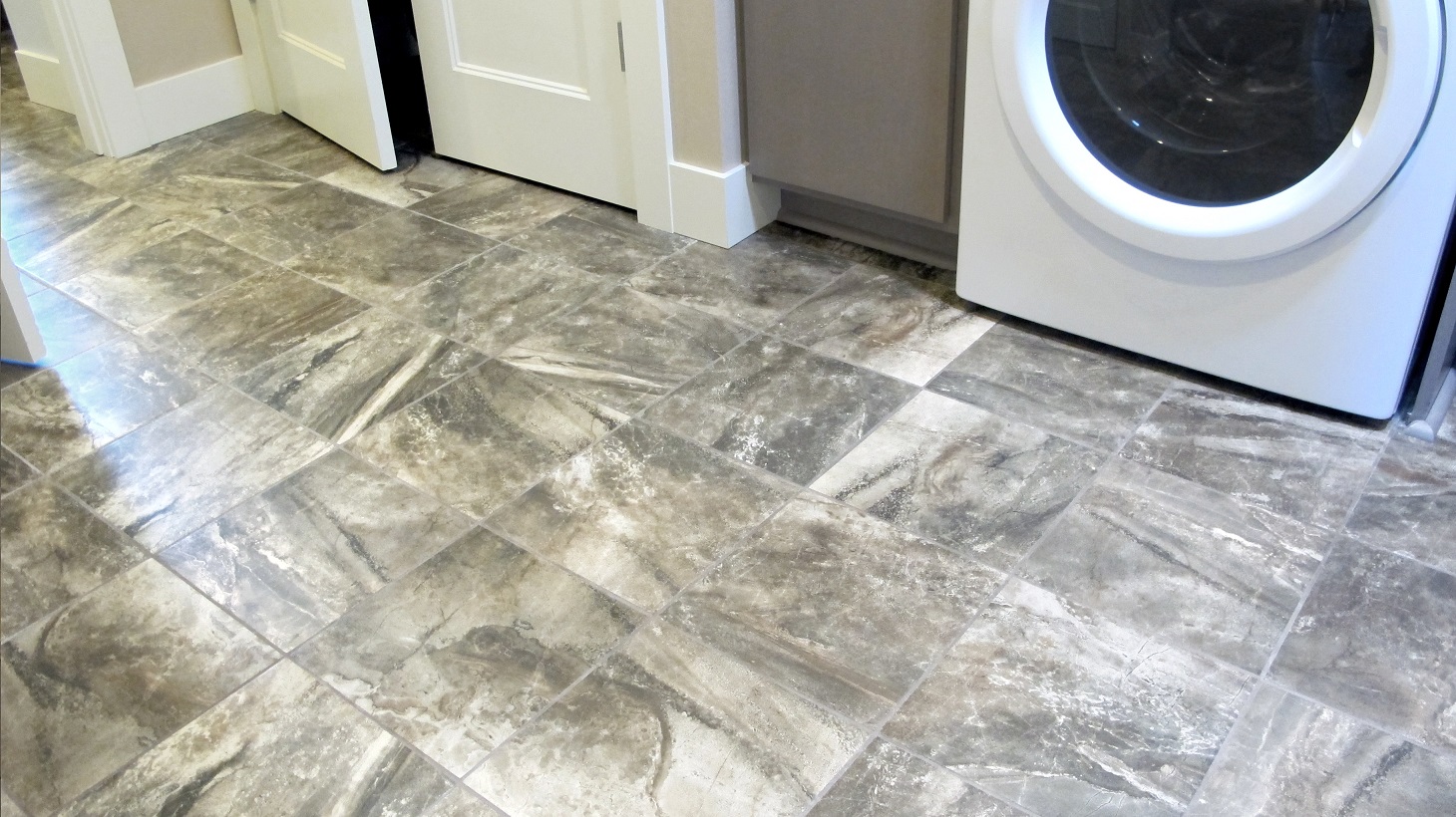 Laundry room white washer & dryer American Olean Danya Riverbed 12x12 brown pattern porcelain ceramic tile baseboard