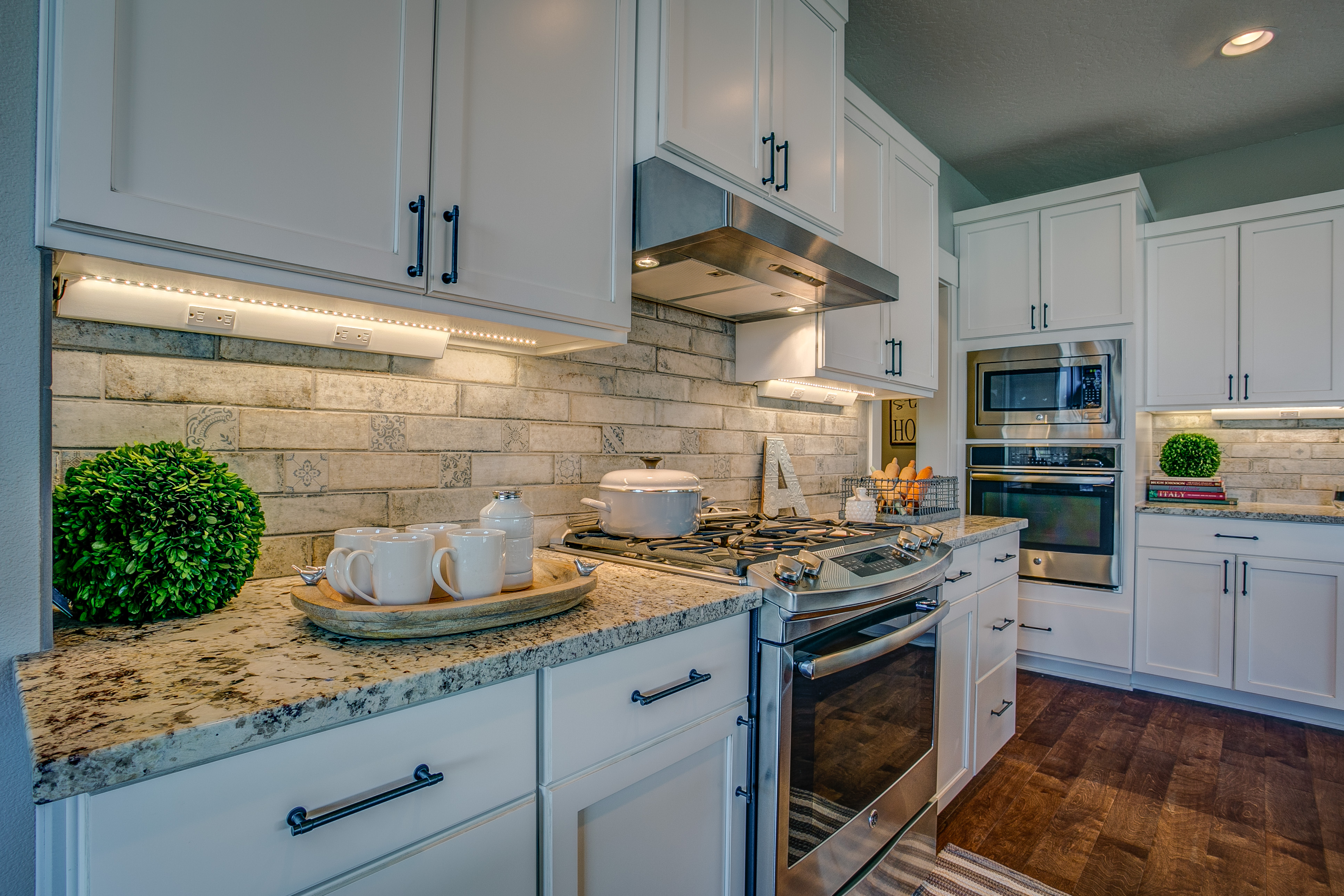 Kitchen backsplash with granite counters and white cabinets.