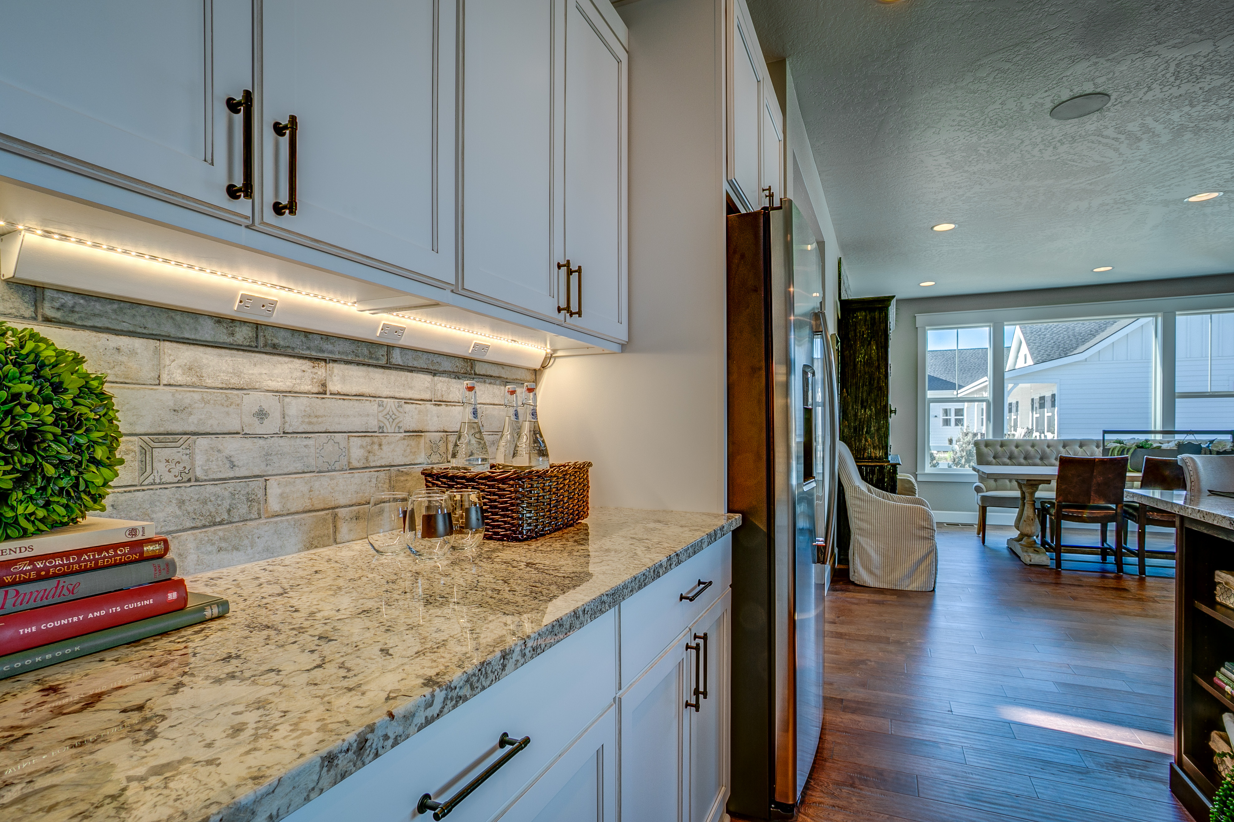 Kitchen backsplash with granite counters and white cabinets.